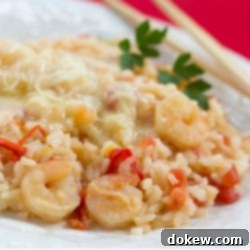 Scrumptious One-Pot Shrimp and Rice Delight 2 Close-up of a white plate featuring Savory One-Pot Shrimp with Rice, garnished with melted Monterey Jack cheese, diced tomatoes, and bell pepper strips.