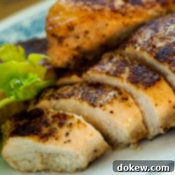 Easy Skillet Chicken Bake 3 Sliced chicken breast on a white plate.