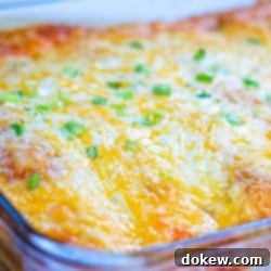 Cheese and Onion Enchiladas 9 Clear baking dish with enchiladas covered with cheese and diced green onions.