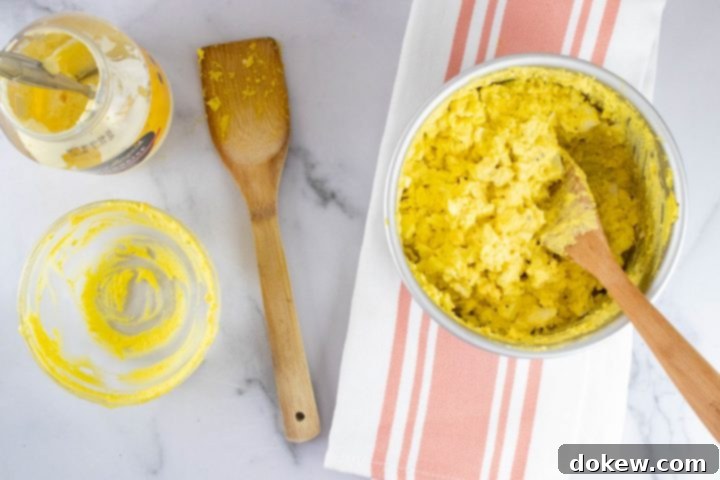 instant-pot-no-peel-egg-salad-ip-10-min Overhead view of partially prepared egg salad with an open mayonnaise jar and a wooden spoon