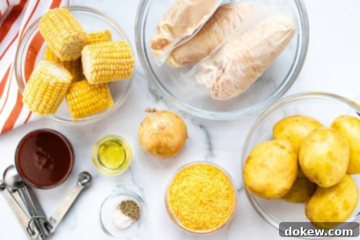 Gathering Ingredients for Crockpot BBQ Chicken Dinner All the raw ingredients for a Crockpot BBQ Chicken Dinner are neatly arranged on a white marble countertop. This includes clear glass bowls of small corn on the cob, individually wrapped frozen chicken breasts, whole unpeeled gold potatoes, a bowl of shredded cheddar cheese, a small bowl with salt and pepper, metal measuring spoons, a bowl of barbecue sauce, a bowl of vegetable oil, and a medium onion, all set beside an orange and white striped napkin, ready for meal prep.