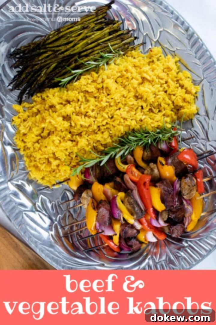 beef-vegetable-kabobs-pin-2-min Large pewter platter of yellow rice, grilled asparagus, and grilled beef kabobs with bell peppers, red onions, and mushrooms with text Beef & vegetable kabobs Add Salt & Serve