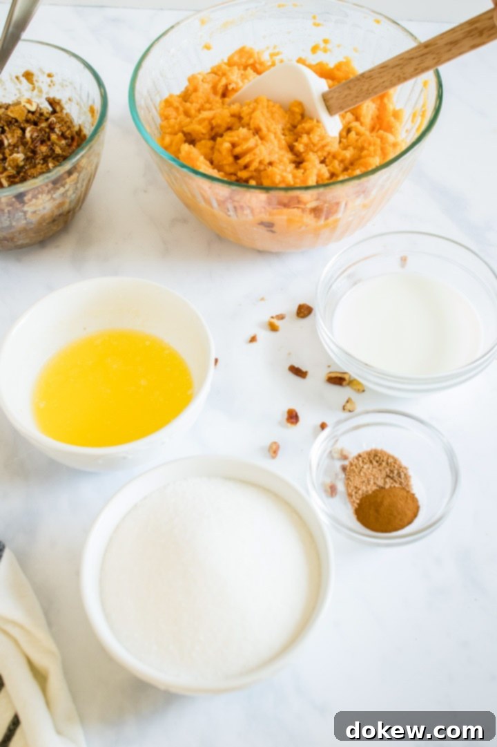 sweet-potato-casserole-ip-3-min Ingredients for creamy sweet potato casserole: streusel topping, mashed sweet potatoes, melted butter, sugar, ground nutmeg, ground cinnamon, and milk in measuring cups