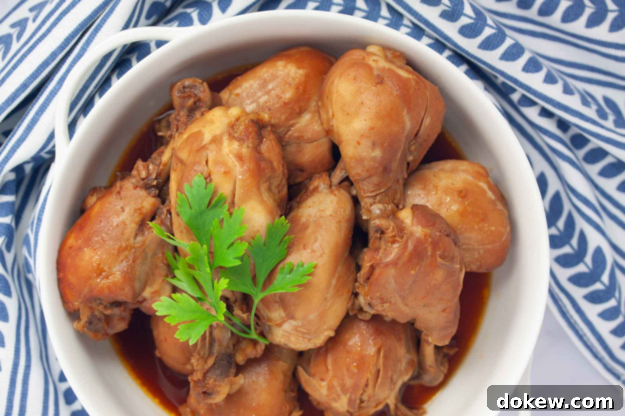 Cooked chicken legs with the meat falling off of the bones in a serving dish.