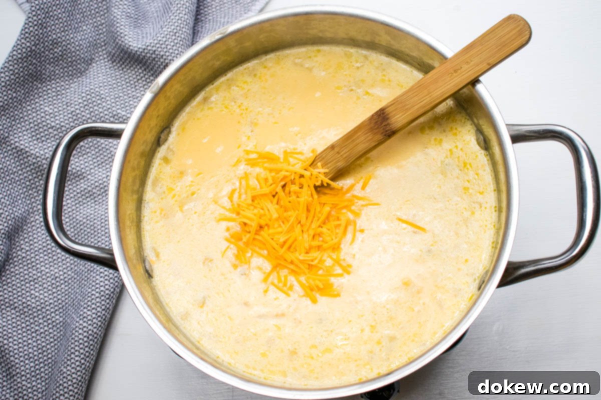 30-Minute Hash Brown Potato Soup 6 Potato soup with hash browns after simmering and just after adding shredded cheddar cheese.