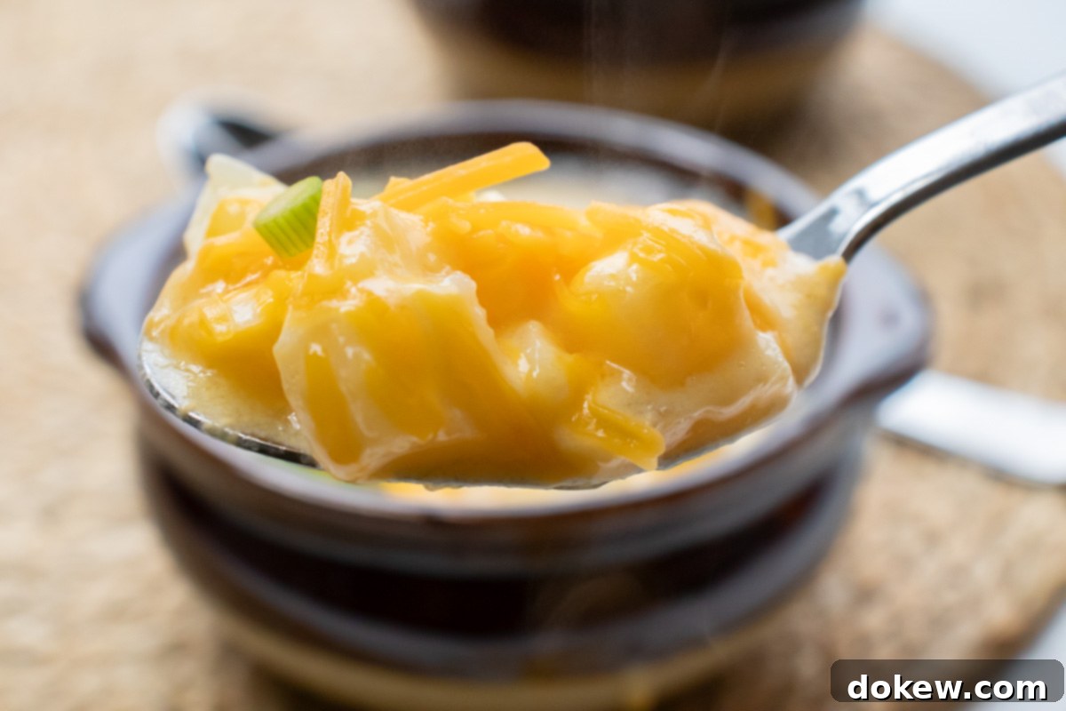 30-Minute Hash Brown Potato Soup 8 Spoonful of potato soup with hash browns held in front of a bowl of the soup.