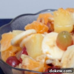 Paradise Fruit Medley 3 A beautifully arranged tropical fruit salad with grapes, mandarin oranges, pineapple chunks, sliced bananas, and walnuts.