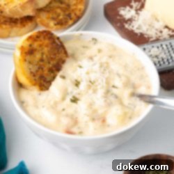 Homemade Olive Garden Chicken Gnocchi Soup 11 A bowl of creamy homemade Chicken Gnocchi Soup with Parmesan and garlic bread, mimicking the Olive Garden classic.