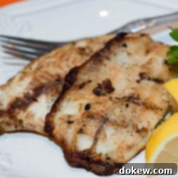 Effortless 5 Ingredient Asian Glazed Fish 3 White plate with fish fillets garnished with lemon wedges and parsley