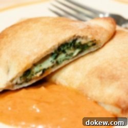 Quick Spinach Calzones 4 Spinach calzones on a plate with spaghetti sauce