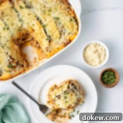 Easy Make-Ahead Zucchini Lasagna 9 White plate with a piece of Freezer Zucchini Lasagna and a fork. Beside the plate is a casserole dish with the rest of the Freezer Zucchini Lasagna.