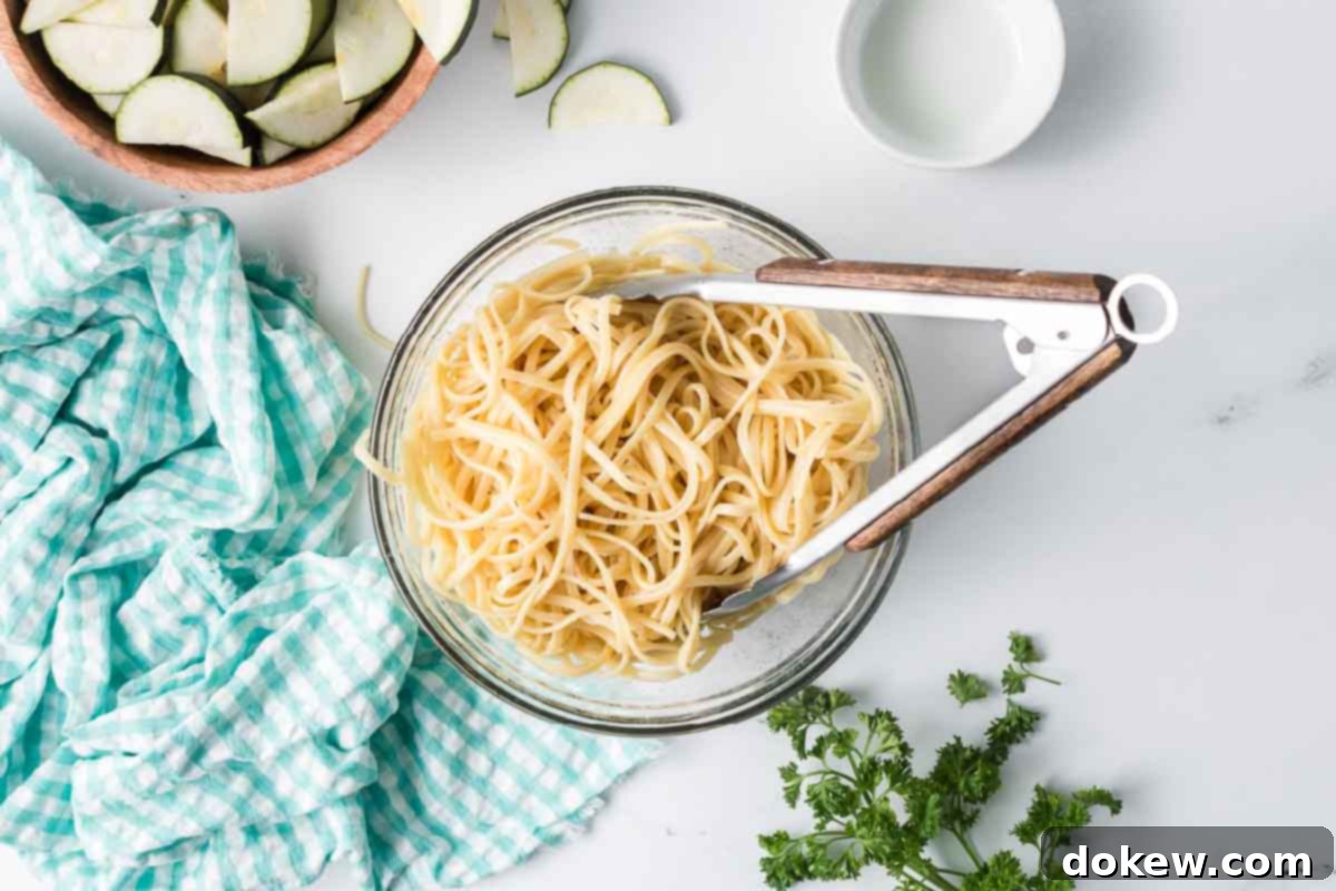 Fresh Zucchini Linguine 4 Cooked linguine in a bowl with a bowl of sliced zucchini nearby, ready for combination.