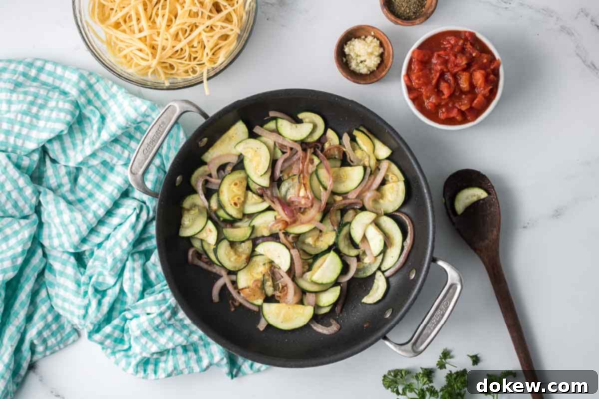 Fresh Zucchini Linguine 6 Sliced zucchini and red onion sautéing together in a skillet.