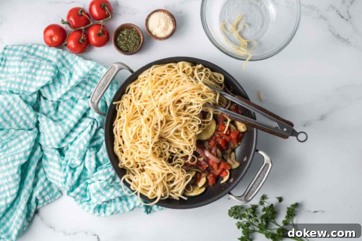 Fresh Zucchini Linguine 8 Hot cooked linguine being added to the skillet with the vibrant zucchini and tomato sauce.