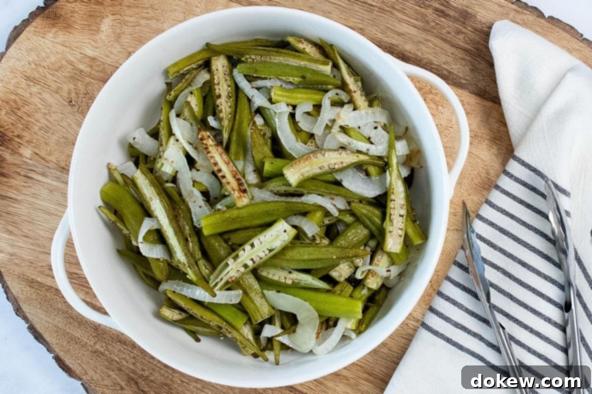Effortless Sheet Pan Roasted Okra and Onions 2 A white bowl filled with perfectly roasted and caramelized sliced okra and onions, showcasing their golden-brown edges and inviting texture, ready to serve as a delicious and healthy side dish.
