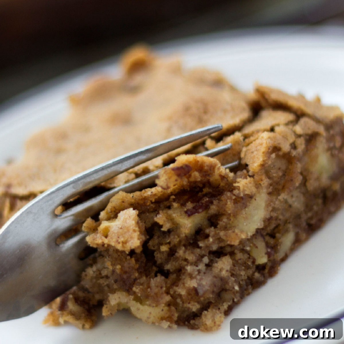 Spiced Apple Walnut Bars 11 A fork cutting into an Apple Walnut Bar that is crisp on the top and moist on the inside.