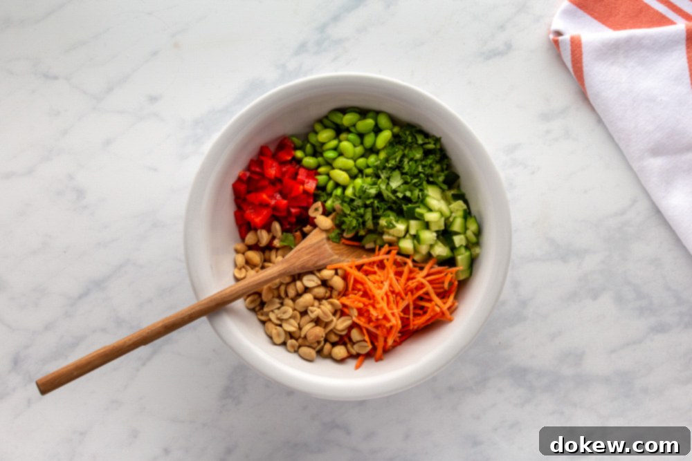 Thai Sesame Noodle Bowl 6 Carrots, Red Bell Pepper peanuts, edamame, and cilantro in a bowl