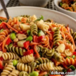 Thai Sesame Noodle Bowl 9 Colorful rotini pasta in a bowl with diced peppers and nuts