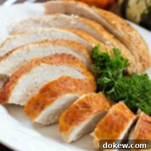 No-Fuss Roast Turkey with Homemade Gravy 3 Sliced roasted turkey breast with golden brown skin on a white plate garnished with parsley