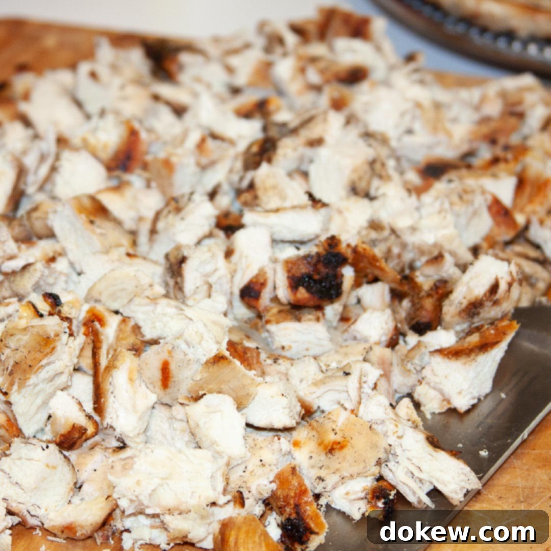 Freezer-Ready Flavor: Marinated Grilled Chicken 2 Freshly chopped grilled chicken pieces neatly arranged on a wooden cutting board, accompanied by a sharp chef's knife, highlighting the ease of meal preparation.