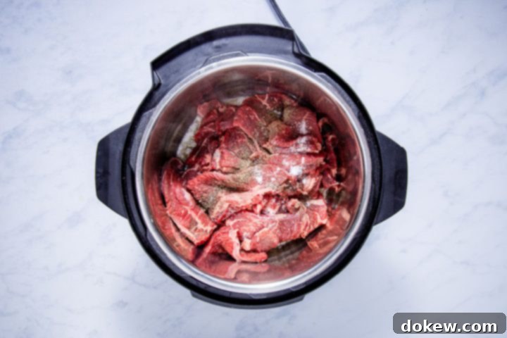 Ultimate Instant Pot French Dip with French Onion Soup 4 seasoned sliced chuck steak in the instant pot