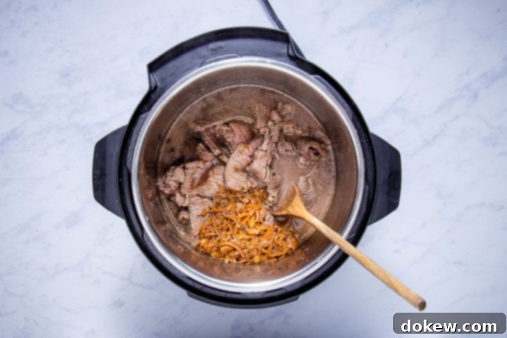 Ultimate Instant Pot French Dip with French Onion Soup 5 sliced sautéed chuck steak, french onion soup, and beef consomme in the instant pot