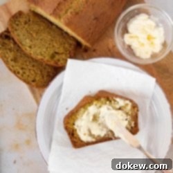Effortless Zucchini Bread 4 Overhead shot of a loaf of zucchini bread with a slice being spread with clotted cream and text Zucchini Sweet Bread, recipes and ideas using zucchini
