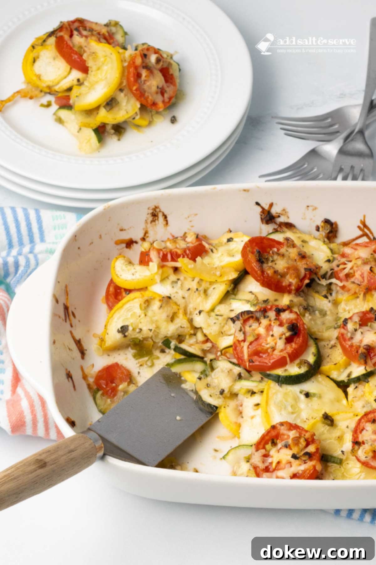 Rustic Tomato and Squash Bake 6 Baked layered casserole of yellow squash, zucchini, and tomatoes with herbs and cheese in a baking dish with a serving on a plate beside the dish.