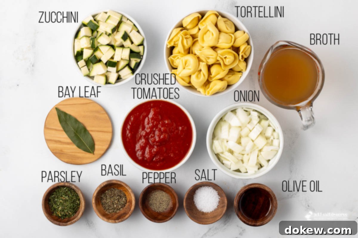 Garden Zucchini Tortellini Pot 3 A selection of fresh ingredients laid out for tomato zucchini soup, including olive oil, onions, zucchini, tomatoes, and herbs.