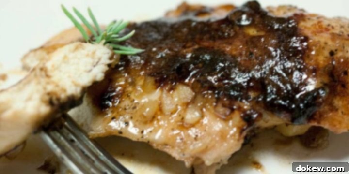 Sweet Garlic Chicken Chicken breast covered in a brown sugar sauce on a white plate. There is a fork holding a small piece of chicken