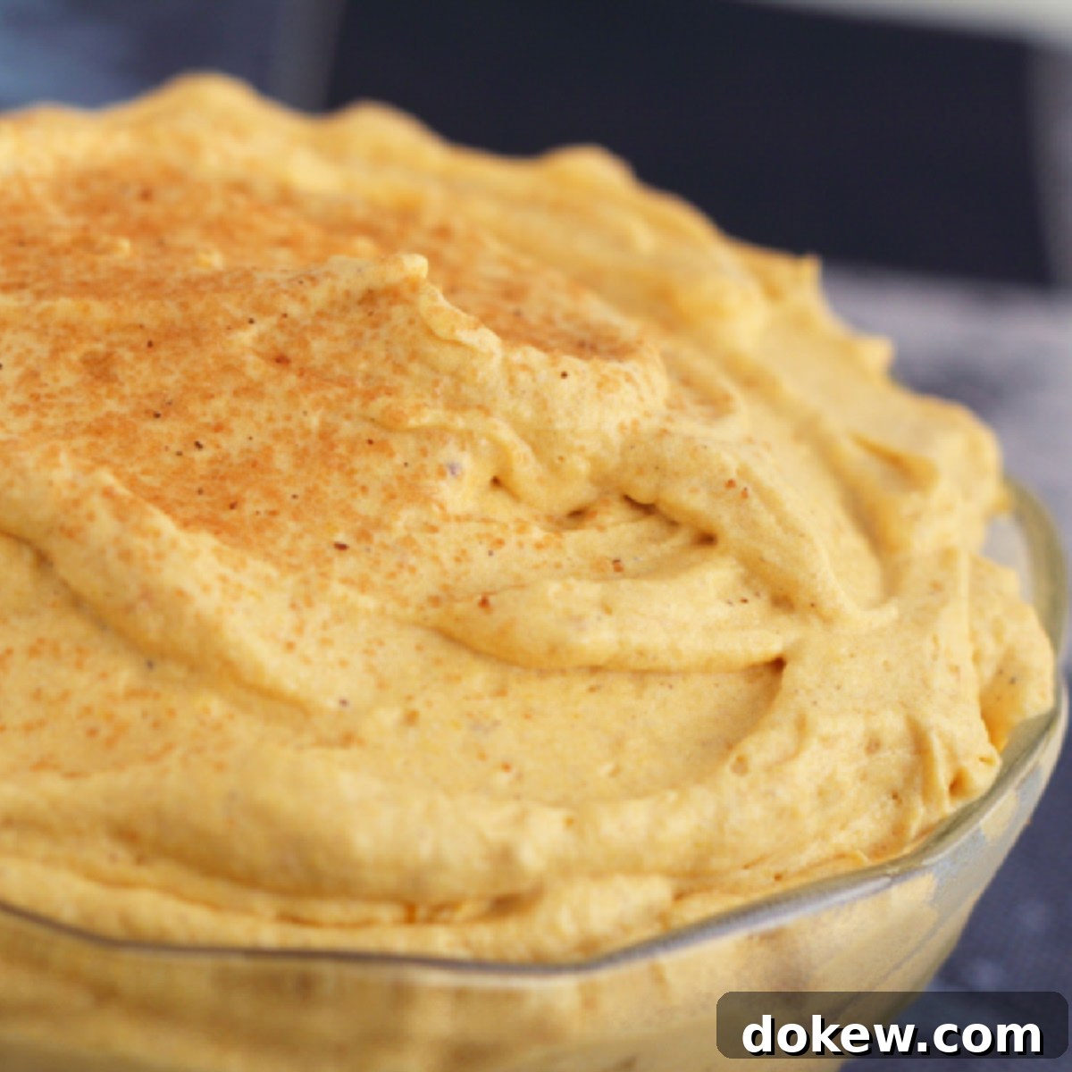 Silky Pumpkin Mousse garnished with a dusting of cinnamon, ready to serve in a elegant glass.