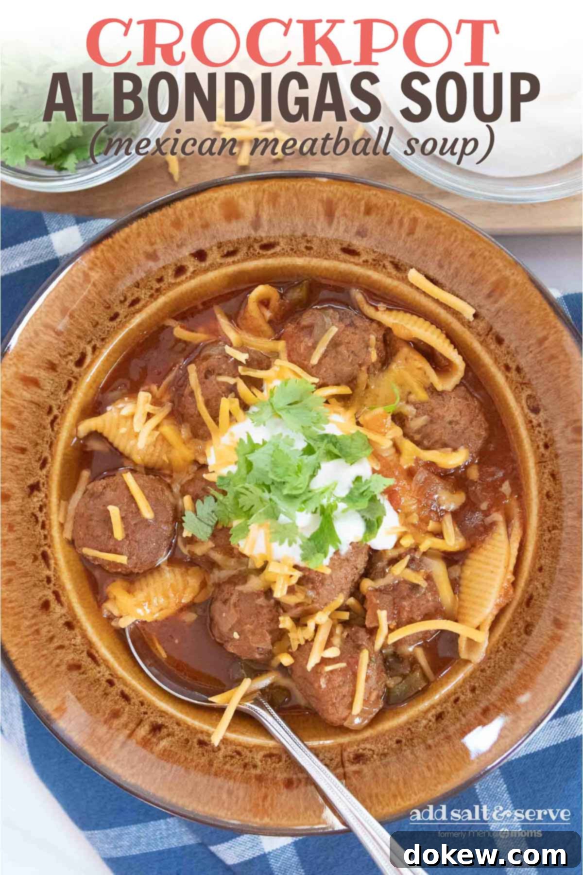 Crockpot Albondigas Soup (Mexican Meatball Soup) Overhead shot of albondigas soup (Mexican meatball soup) in a brown wide-rim bowl garnished with sour cream, grated cheddar cheese, and fresh cilantro