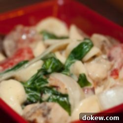 No-Fuss Florentine Orecchiette 2 Red square bowl with orecchiette pasta, sliced onion, chopped bacon, roasted bell peppers, cooked spinach, and Alfredo sauce.