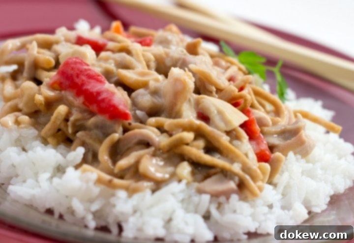 Easy Cashew Chicken Recipe Chopped chicken with red peppers and mushrooms in a creamy sauce over white rice and garnished with chow mein noodles