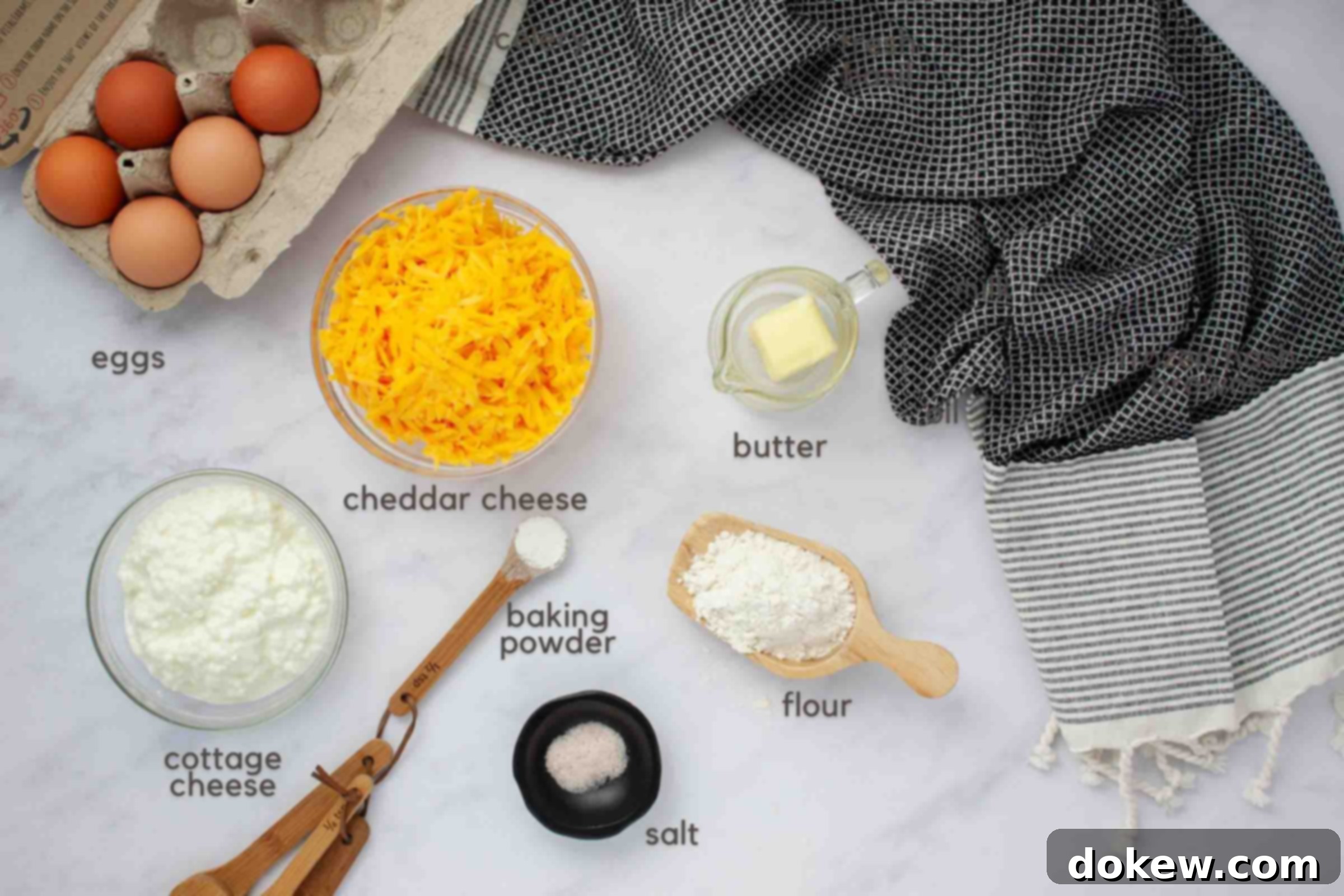 Protein-Rich Crustless Cottage Cheese Bake 3 Ingredients to make quiche on a counter: eggs, shredded cheddar cheese, cottage cheese, baking powder, salt, flour, and butter.