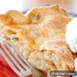 Perfect Homemade Apple Pie 2 Slice of apple pie with top crust and a scoop of vanilla ice cream with a fork