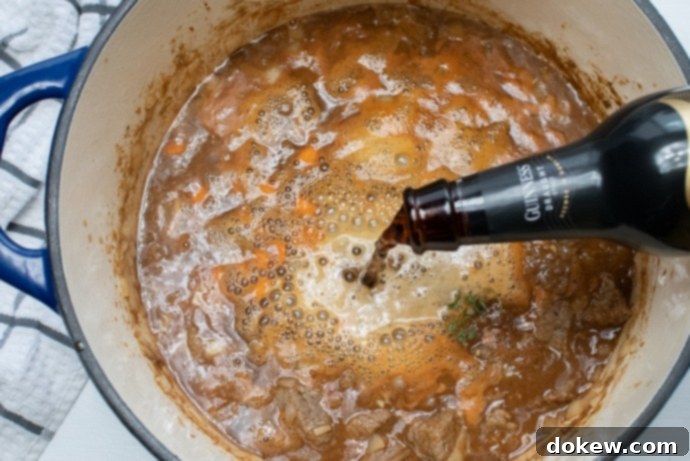 Beef and Guinness Stew Pot of Beef Stew with Guinness beer pouring in
