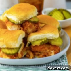 Sweet Heat Sliders: Done in a Flash 12 A pile of hot honey chicken sliders with pickles on a plate.