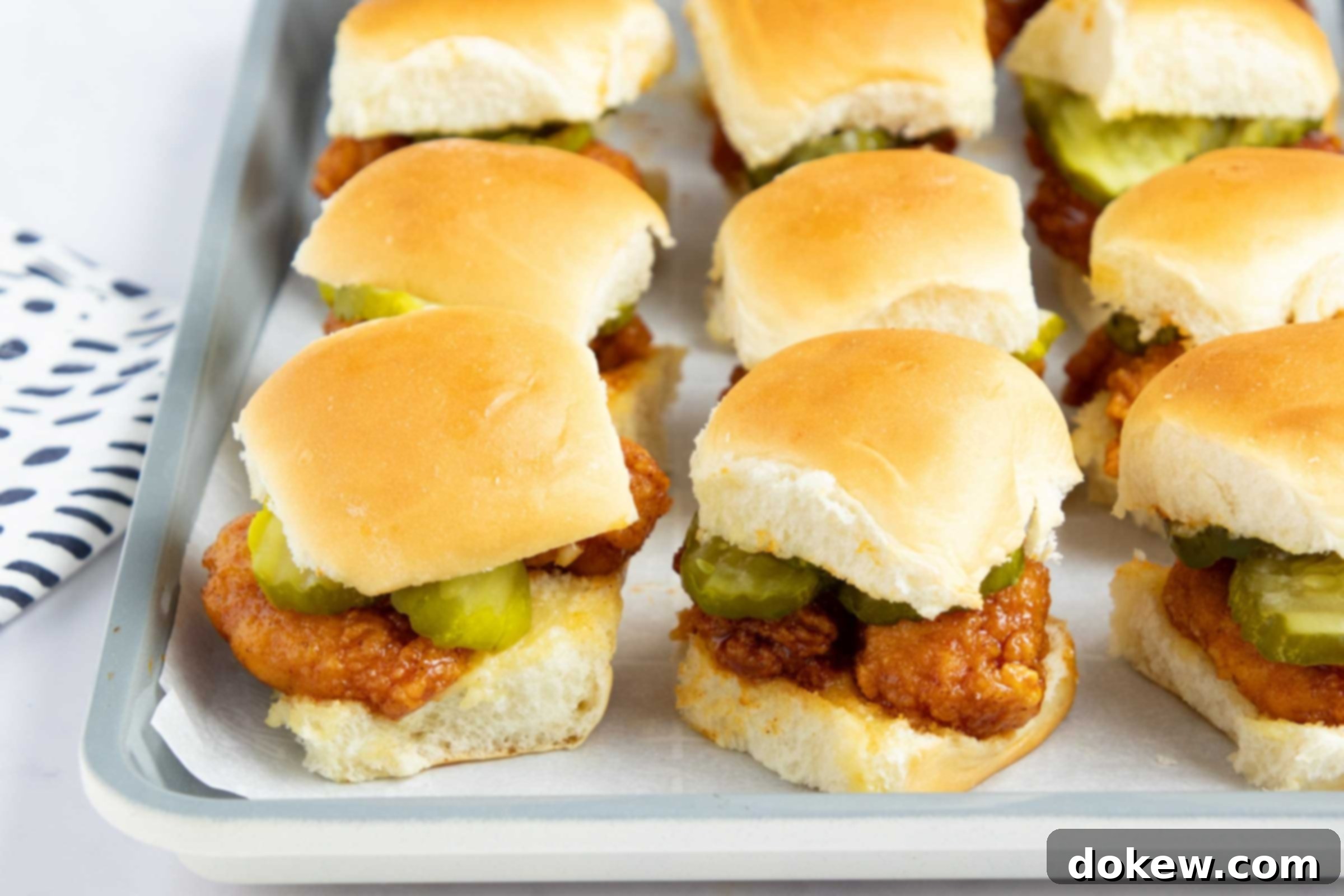 Sweet Heat Sliders: Done in a Flash 10 Hot honey chicken sliders with pickles on a baking sheet.