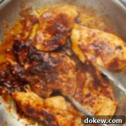Tropical Chili Lime Chicken with Coconut Lime Sauce 8 Boneless, skinless chicken breasts in a rich chili sauce being sautéed in a skillet.