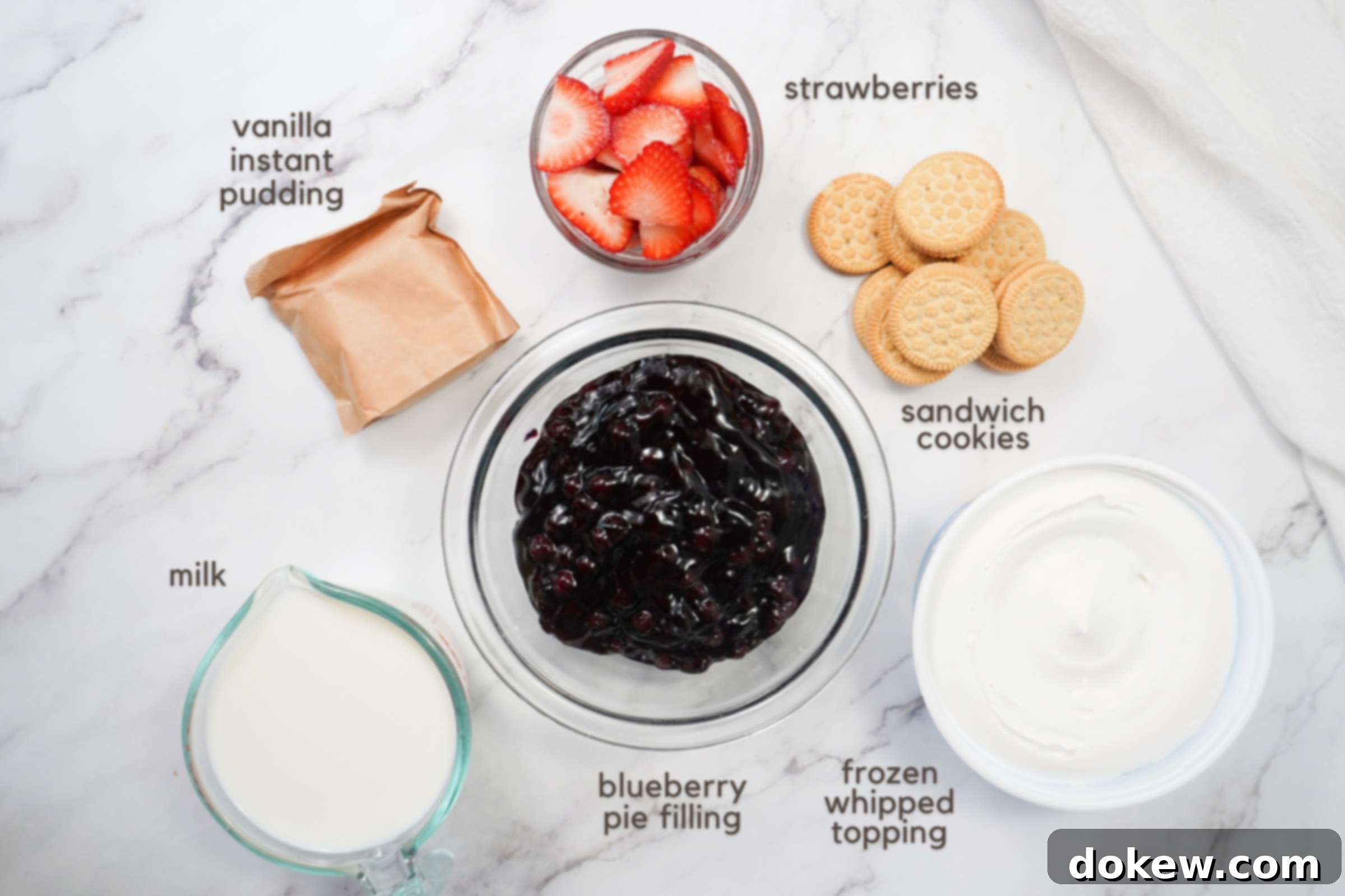 Patriotic Parfaits 3 Labeled ingredients on a counter: Vanilla instant pudding mix, sliced strawberries, sandwich cookies, milk, blueberry pie filling, and frozen whipped topping.