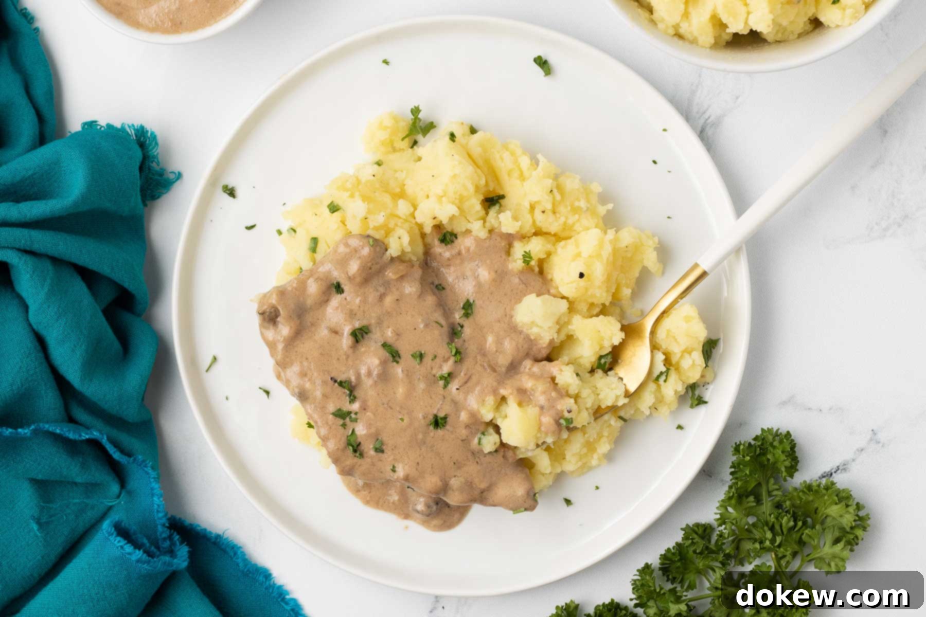 Crock Pot Cube Steak with Creamy Mushroom Sauce 2 Tender Crock Pot Cube Steak with creamy mushroom gravy served over mashed potatoes, ready for a comforting meal.