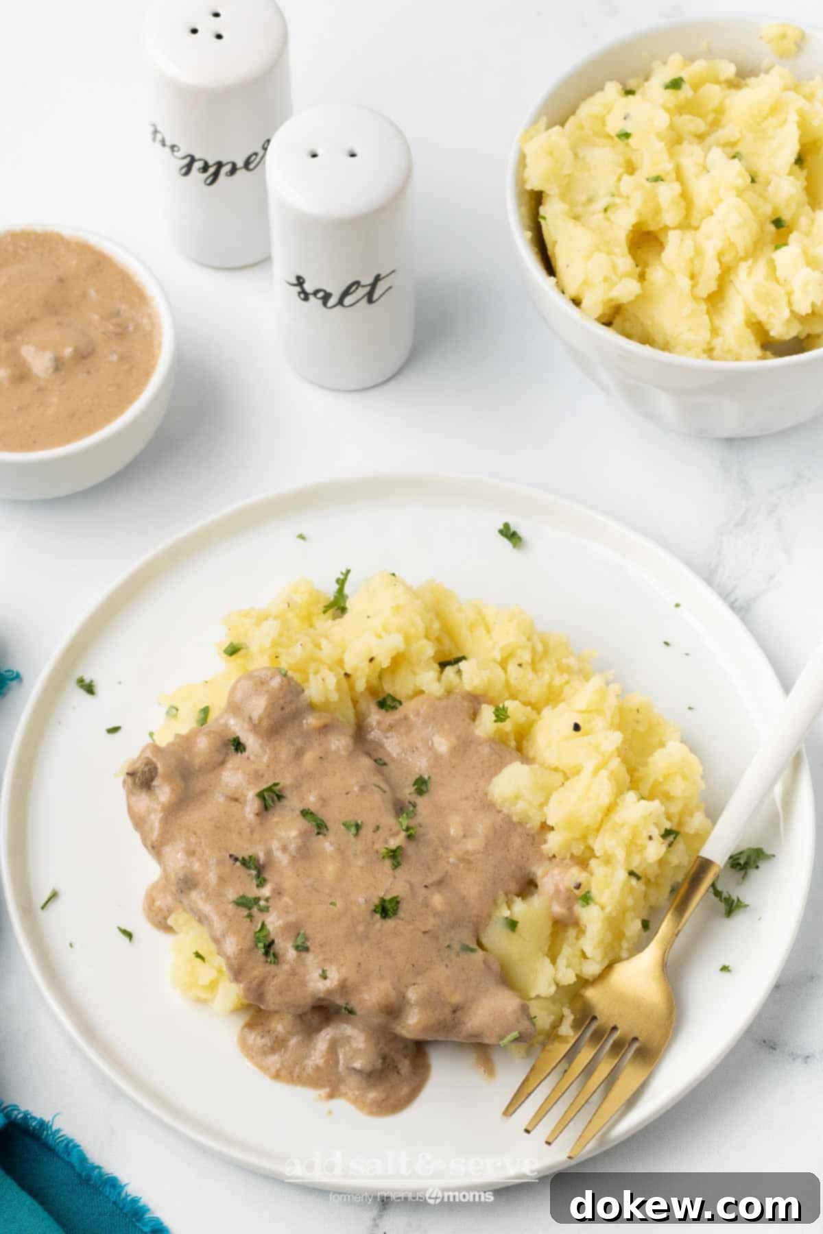 Crock Pot Cube Steak with Creamy Mushroom Sauce 7 A serving of Crock Pot Cube Steak with mushroom soup gravy served over mashed potatoes for a hearty meal.
