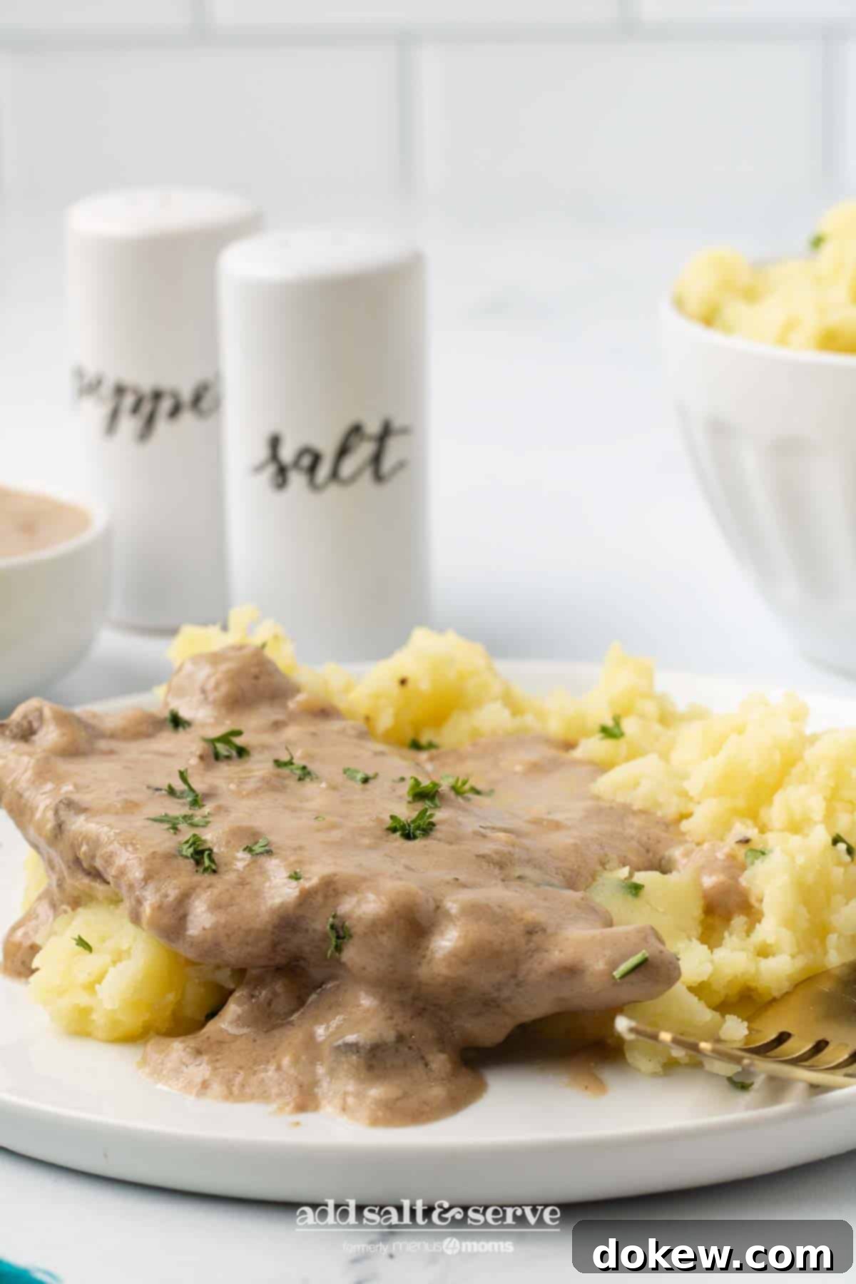 Crock Pot Cube Steak with Creamy Mushroom Sauce 8 Delicious Crock Pot Cube Steak with mushroom soup gravy served over mashed potatoes, showcasing the tender beef and rich sauce.