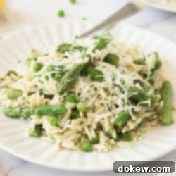 Spring Lemon Orzo with Asparagus, Peas, and Parmesan 7 Plate of orzo with peas and asparagus garnished with grated Parmesan cheese.