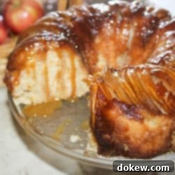 Golden Caramel Apple Bundt 11 Apple upside down bundt cake with a slice removed and caramel sauce dripping down the sides.