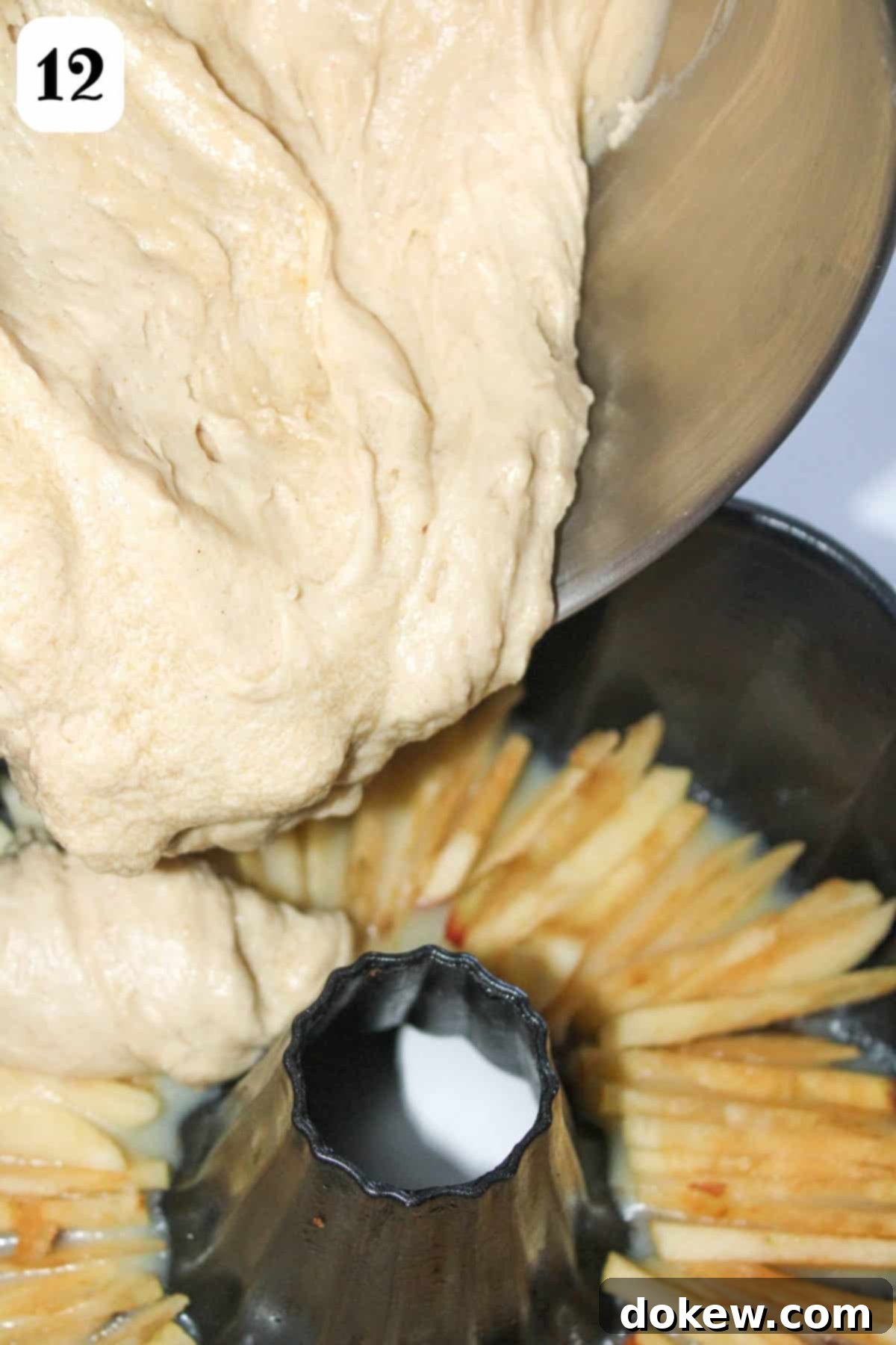 Golden Caramel Apple Bundt 8 12- Adding cake batter over sliced apples in a bundt pan.