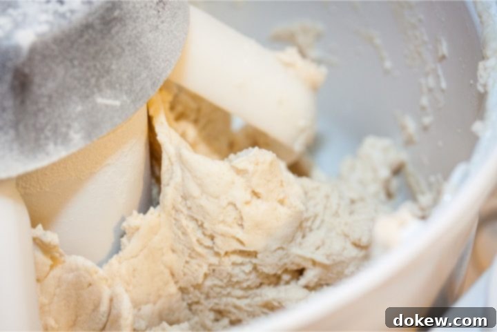 Easy Homemade Buttermilk Biscuits Stand mixer with dough paddles and biscuit dough being mixed