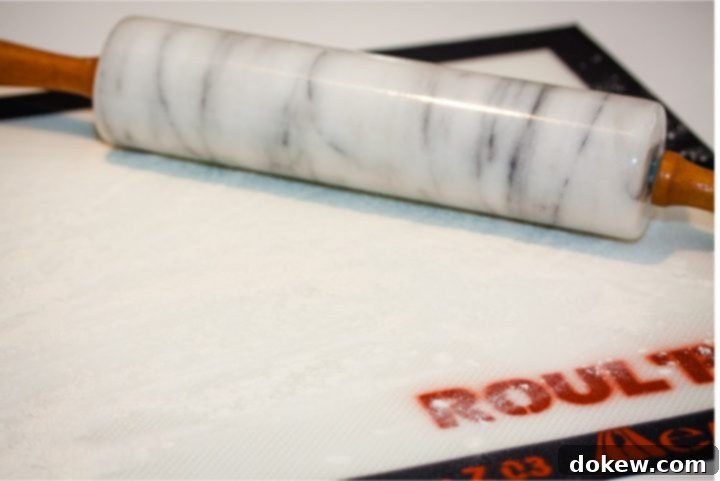 homemade-buttermilk-biscuits-ip-2-min Silicone mat with flour sprinkled on it and a marble rolling pin to the side