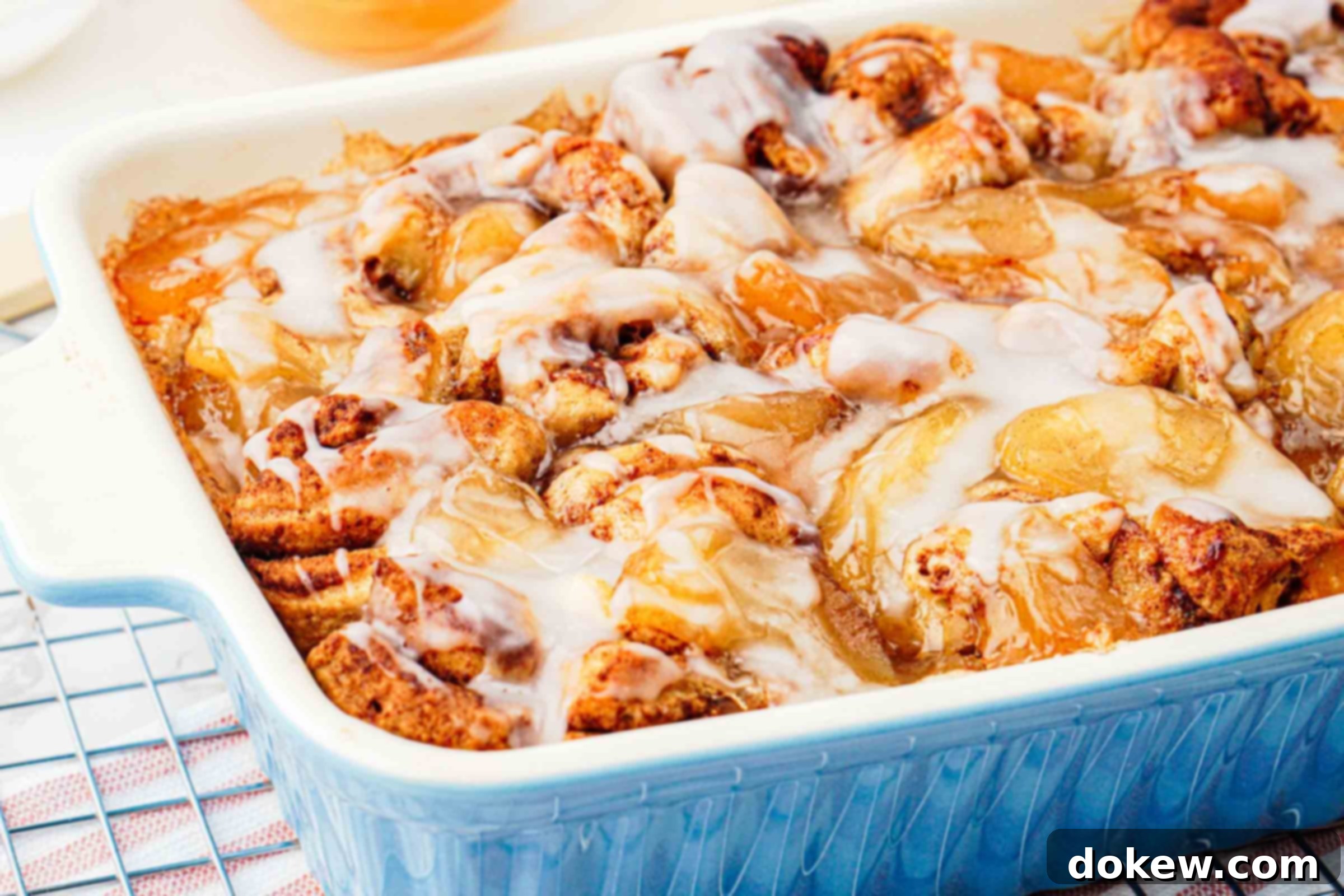 Simple Two-Ingredient Apple Cinnamon Delight 2 Apple cinnamon roll bake in pan with glaze on top, showcasing its golden-brown crust and sweet icing drizzle.